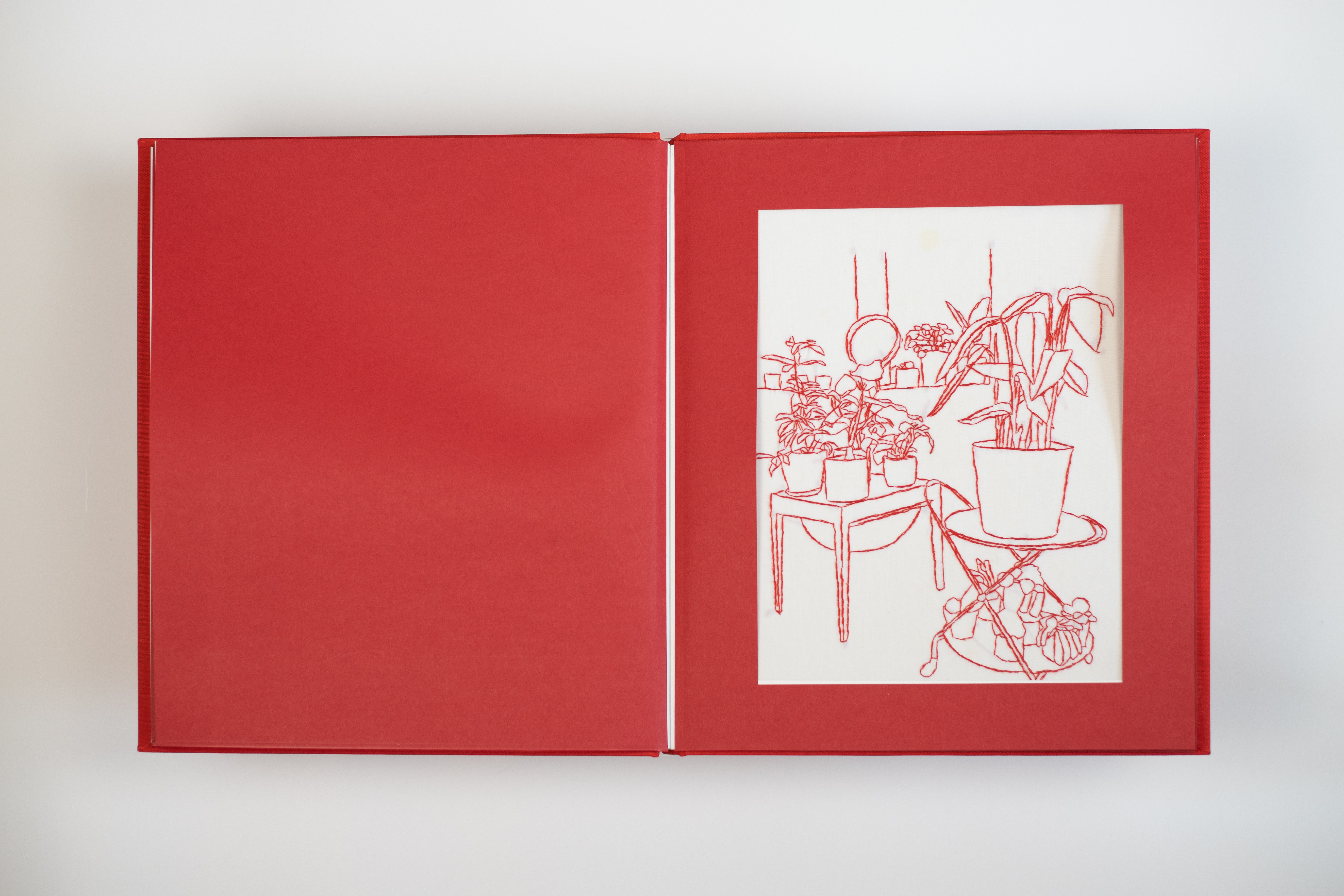 This handmade book showcases delicate red thread artistry, weaving together the simplicity and beauty of daily experiences